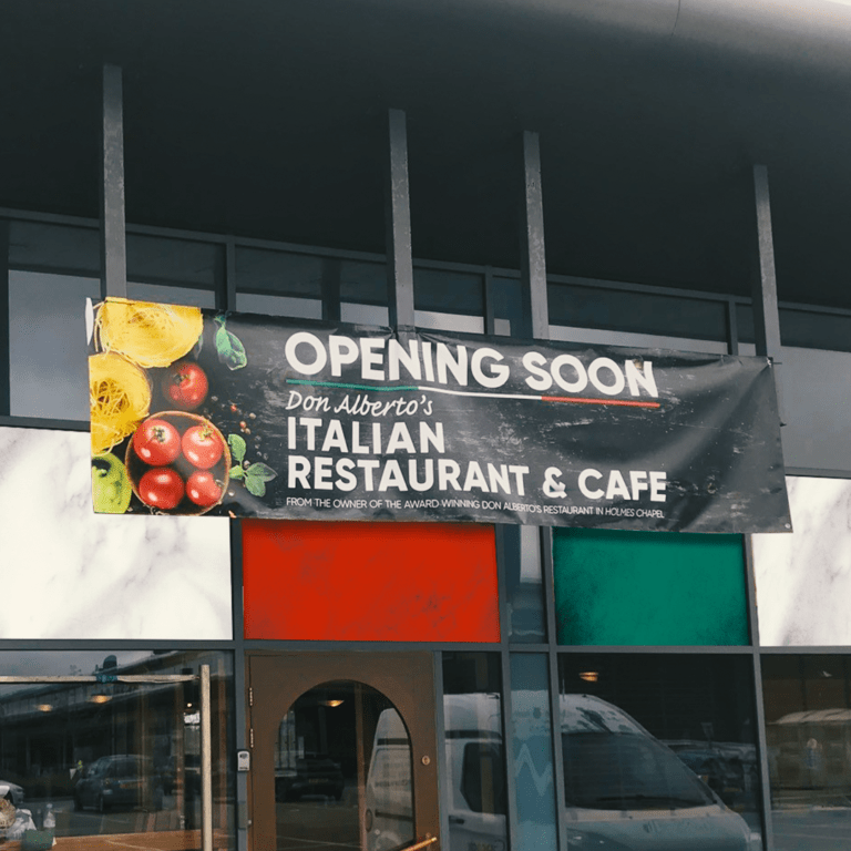 Printed Banner outside of a restaurant that's opening soon.